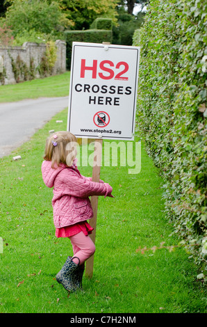 Kleines Mädchen auf die vorgeschlagene Route HS2 Eisenbahnverbindung durch die Chilterns in der Nähe von Hyde Heide. Protest-Zeichen auf der Kapelle Farm, Hyde Ende Stockfoto