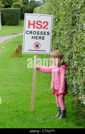 Kleines Mädchen auf die vorgeschlagene Route HS2 Eisenbahnverbindung durch die Chilterns in der Nähe von Hyde Heide. Protest-Zeichen auf der Kapelle Farm, Hyde Ende Stockfoto