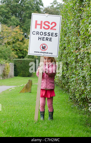 Kleines Mädchen auf die vorgeschlagene Route HS2 Eisenbahnverbindung durch die Chilterns in der Nähe von Hyde Heide. Protest-Zeichen auf der Kapelle Farm, Hyde Ende Stockfoto