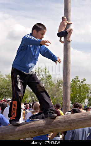 MAGNITOGORSK, Russland - 18. Juni 2011: Tatar traditionelle Unterhaltung - Protokoll Wandern und Klettern am Pol an die Sabantuy Stockfoto