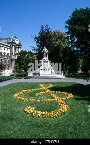 Österreich, Wien, Mozart-Statue im Burggarten Park und einem floralen Violinschlüssel im Vordergrund Stockfoto