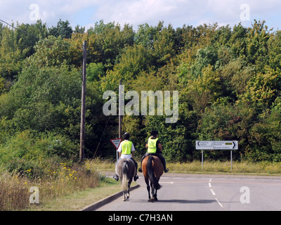 Zwei junge Reitern Reiten auf einer Hauptstraße an einer Straßenkreuzung Stockfoto