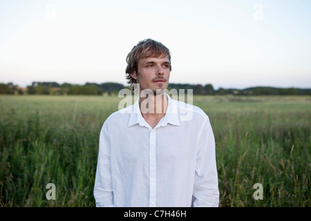 Mann im weißen Hemd sieht auf die Seite im Bereich Stockfoto