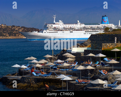 Das Kreuzfahrtschiff Thomson Spirit verlassen den Hafen von Agios Nikolaos auf der griechischen Insel Kreta von Urlaubern beobachtet. Stockfoto