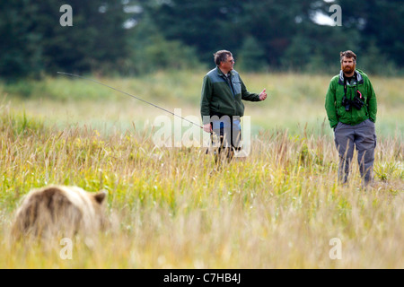 Nordamerikanischen Braunbären (Ursus Arctos Horribilis) Uhren, ein Fischer und ein Mitarbeiter der Park, Lake-Clark-Nationalpark, Alaska Stockfoto