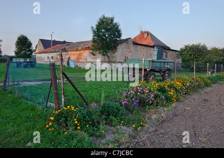 Blumen, Zaun, Anhänger und ein altes Gebäude Stockfoto