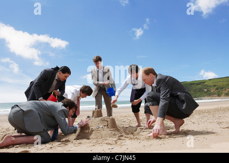 Geschäftsleute, die Sandburg bauen Stockfoto