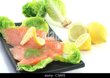 Lachsscheiben mit Zitrone und Dill auf grünem Salat Stockfoto