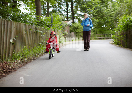 Mutter beobachtete Sohn Fahrt Fahrrad Stockfoto