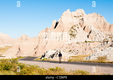 Ein Wanderer Spaziergänge entlang der Badlands Loop Road in Badlands Nationalpark in South Dakota. Stockfoto