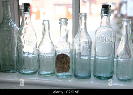 Alte Bierflaschen auf dem Fensterbrett Stockfoto