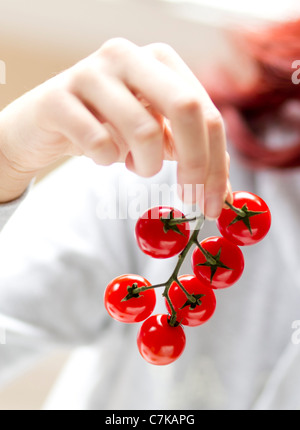 Frau-Holding-Cherry-Tomaten Stockfoto