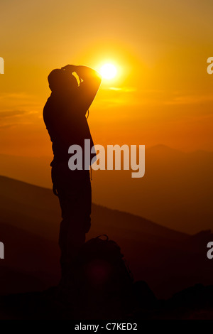 Silhouette der Fotograf unter Bild der Landschaft bei Sonnenuntergang Stockfoto