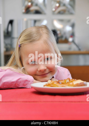 Junges Mädchen, 6, an einem Tisch sitzen Stockfoto