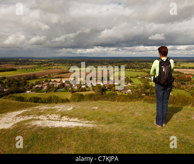 Frau zu Fuß entlang der Devils Dyke, Blick auf das Dorf Fulking und der Weald. Stockfoto
