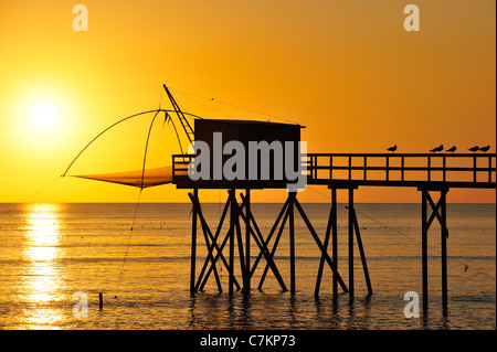Traditionelle Carrelet Fischerhütte mit Aufzug Netto am Strand am Meer bei Sonnenuntergang, Loire-Atlantique, Pays De La Loire, Frankreich Stockfoto