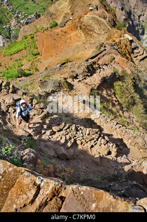 Eine weibliche Walker absteigend kurvenreichen Steig in der Nähe von Cha de Pedra auf Santo Antao in Kap-Verde Inseln Stockfoto
