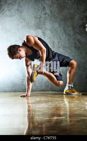 Junger Mann Sport Übungen. Auf Wand Hintergrund. Stockfoto