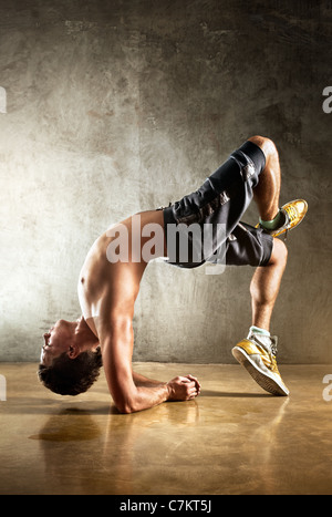 Junger Mann Sport Übungen. Auf Wand Hintergrund. Stockfoto