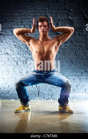 Junger Mann Sport Übungen. Auf Wand Hintergrund. Stockfoto