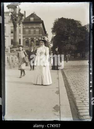 Eine viktorianische Dame, die ihr mit anderen Passanten auf der Straße fotografieren Stockfoto
