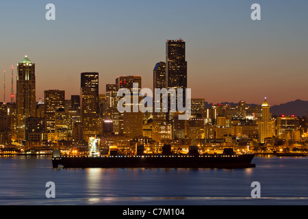 Containerschiff am Puget Sound entlang der Skyline von Seattle Washington im Morgengrauen Stockfoto