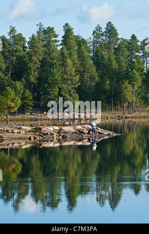 Ein Mann und sein bester Freund Angeln vor dem Frühstück auf Willow Springs Lake, Arizona zu tun. Stockfoto