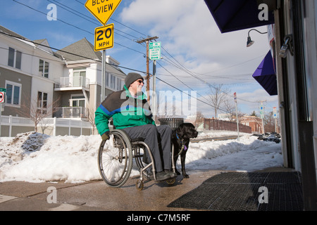 Frau mit Multipler Sklerose vor einem Geschäft für den Einkauf mit einem Servicehund Stockfoto