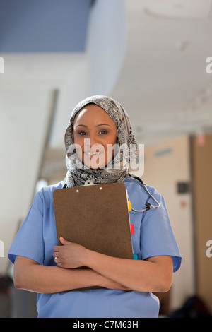 Porträt von eine Krankenschwester, ein medizinisches Gutachten halten und Lächeln Stockfoto