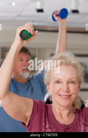 Mann und Frau, die das Training mit Hanteln im Fitnessstudio Stockfoto