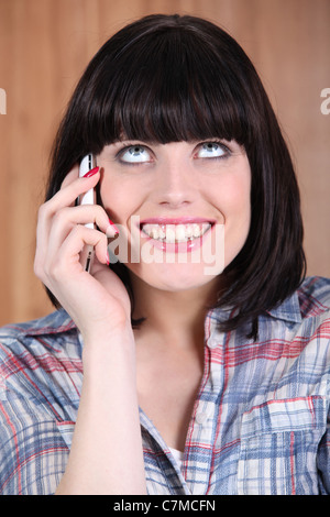 Frau mit einem breiten Grinsen am Telefon sprechen Stockfoto