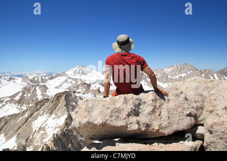 Rückansicht eines Mannes sitzen auf Feder Peak Gipfel die Aussicht genießen Stockfoto