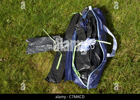 ein kleines Zelt in einem Beutel auf dem Rasen liegend Auspacken Stockfoto