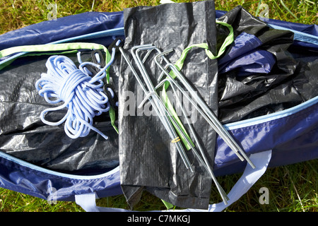 Beutel mit Heringen Auspacken ein kleines Zelt in einem Beutel auf dem Rasen liegend Stockfoto