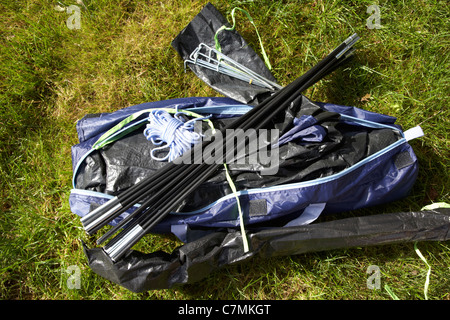 Zeltstangen Auspacken ein kleines Zelt in einem Beutel auf dem Rasen liegend Stockfoto