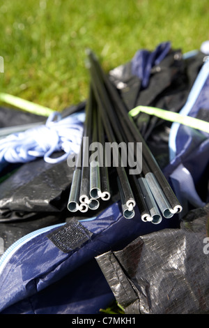 Zeltstangen Auspacken ein kleines Zelt in einem Beutel auf dem Rasen liegend Stockfoto