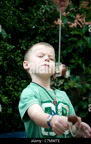 Junge, ein traditionelles Spiel Conkers, Kastanien-, Conkers, Ausschnitt, Spiel, hand, halten, Pferd, Rosskastanie, isoliert, Stockfoto