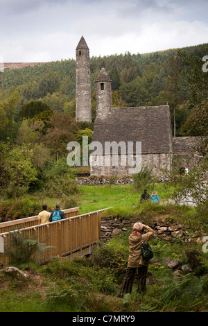 Irland, Co. Wicklow, Glendalough, historische klösterliche Website, Besucher fotografieren Küche und Rundturm Stockfoto