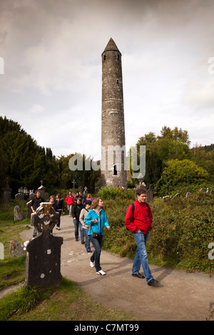 Irland, Co Wicklow, Glendalough, historische klösterliche Stätte, Gruppe von Touristen am runden Turm Stockfoto