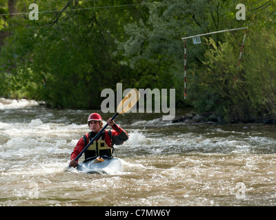 Ein Wildwasser-Kajakfahrer läuft die Slalomstrecke in Golden, Colorado Clear Creek Wildwasser-Park. Stockfoto