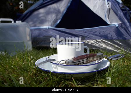 Wasser Behälter Weissblech Cup und camping Werkzeug Utensilien vor die offene Tür eines Zeltes Stockfoto