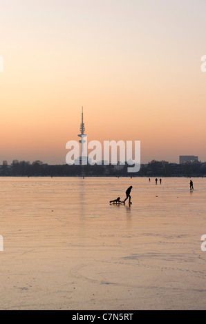 Fest gefroren Außenalster, Außenalster, nach Sonnenuntergang, Leute, Unterhaltung, Eis, Schnee, winter, Hamburg, Deutschland Stockfoto