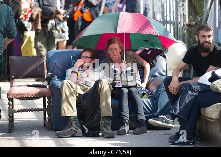 Dale Farm Räumung. Unterstützer der Reisenden sitzen auf einem alten Sofa unter einem Regenschirm warten auf Nachrichten vom High Court. Stockfoto