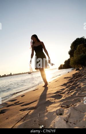 Junge Frau mit einem abendlichen Spaziergang entlang der Elbe in Hamburg, Norddeutschland Stockfoto