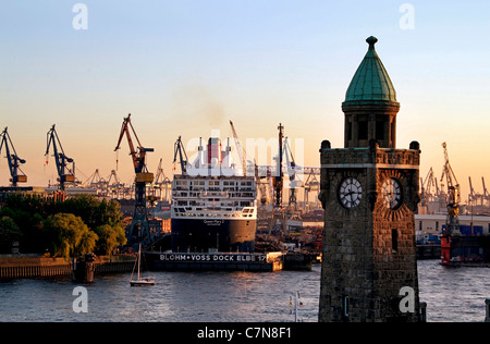 Silhouette von den Landungsbrücken mit Kreuzfahrt Passagierschiff Queen Mary 2 in den Werften, Hamburg, Deutschland Stockfoto