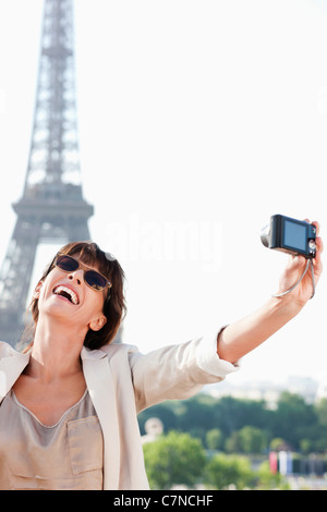 Frau, die ein Bild von sich selbst mit dem Eiffelturm im Hintergrund, Paris, Ile de France, Frankreich Stockfoto