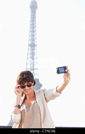 Frau, die ein Bild von sich selbst mit dem Eiffelturm im Hintergrund, Paris, Ile de France, Frankreich Stockfoto