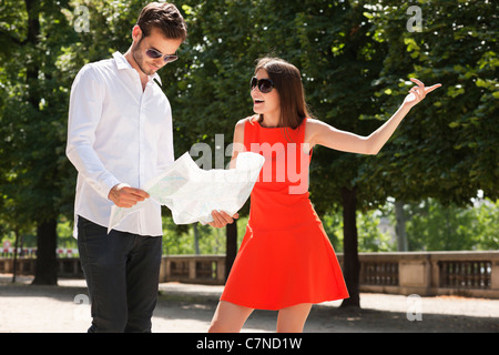 Mann liest eine Karte mit einer Frau zeigt, Terrasse De l ' Orangerie, Jardin des Tuileries, Paris, Ile de France, Frankreich Stockfoto