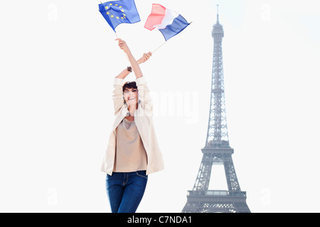 Frau hält eine Fahne der Europäischen Union und eine französische Flagge mit dem Eiffelturm im Hintergrund, Paris, Ile de France, Frankreich Stockfoto