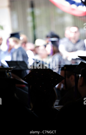 Silhouetten der Hochschule oder High School Absolventen tragen die traditionelle Mütze und Mantel. Geringe Schärfentiefe. Stockfoto